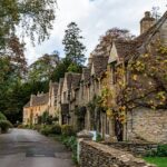 Street lined with honey-stone buildings in Castle Combe, a romantic Cotswolds village