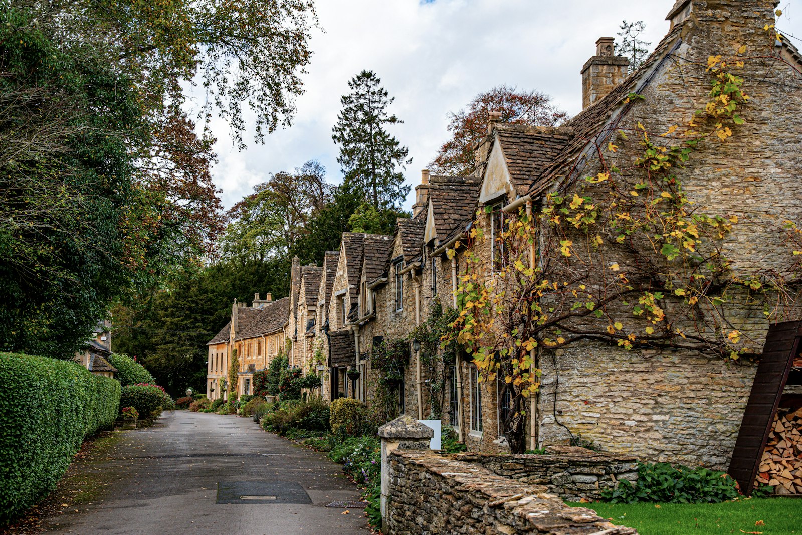 Street lined with honey-stone buildings in Castle Combe, a romantic Cotswolds village