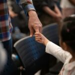 Adult hand holding a child's hand, reflecting the care involved in fostering